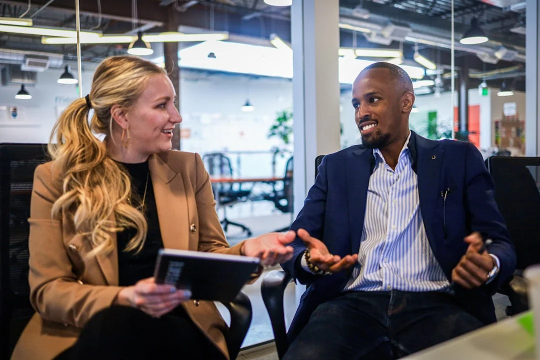 about-us Team members discussing digital graphs on a tablet in a modern office setting.